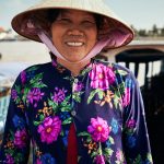woman in woven hat and floral button-up long-sleeved shirt